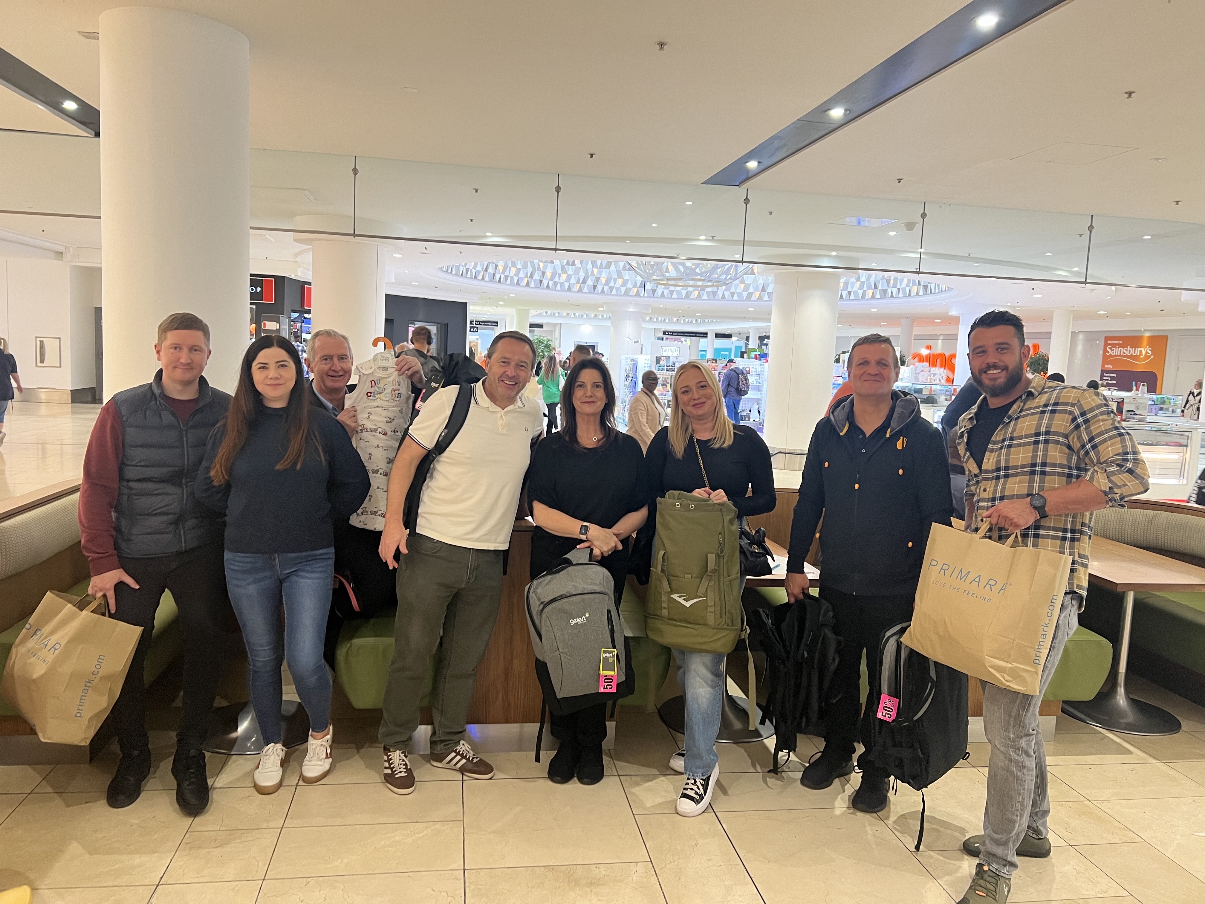 A group of volunteers are pictured in a shopping centre with items purchased for the kits.